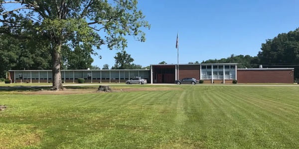 Front lawn and exterior view of a school building under a clear blue sky.